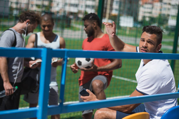 istock multicultural soccer team resting on stadium together before game 815169560