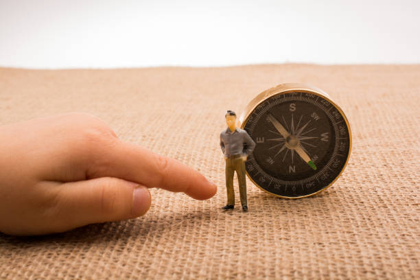 istock Figurine by the side of a compass 815169626