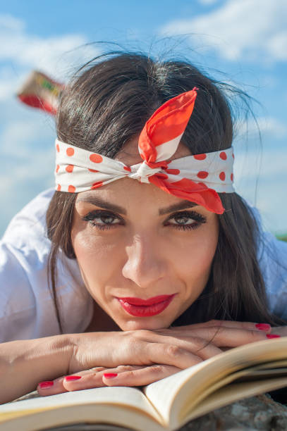 istock Beautiful girl lying on wall and enjoying a book reading 815170384