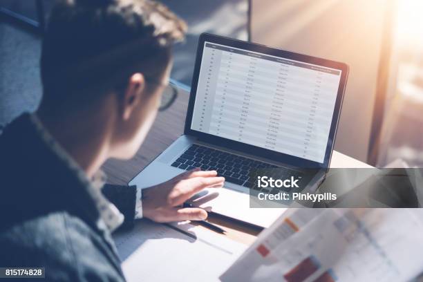 Closeup View Of Banking Finance Analyst In Eyeglasses Working At Sunny Office On Laptop While Sitting At Wooden Tablebusinessman Analyze Stock Report On Notebook Screenblurred Backgroundhorizontal Stock Photo - Download Image Now