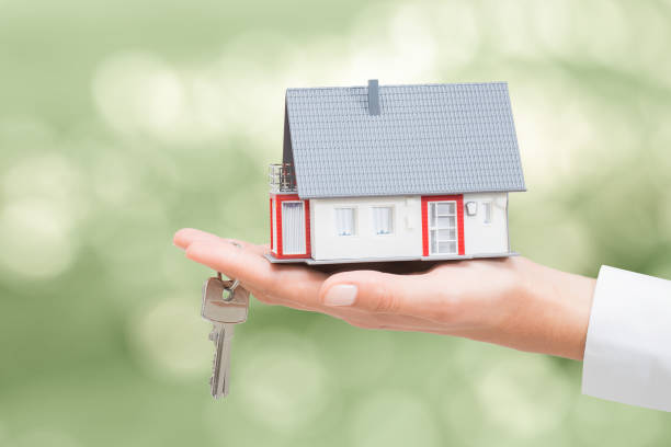 istock Real estate agent with house model and keys. 815188620