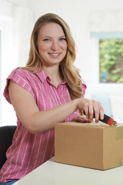 istock Woman Using Knife To Open Package At Home 815189084