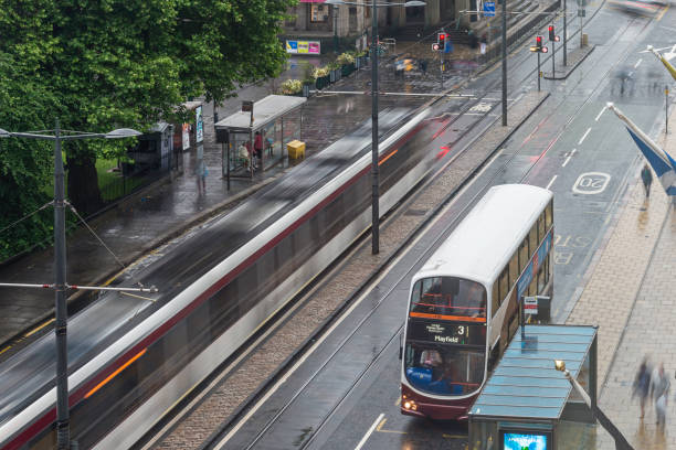 Buses and City Trains in Prices street , Edinburgh, in a rainy afternoon