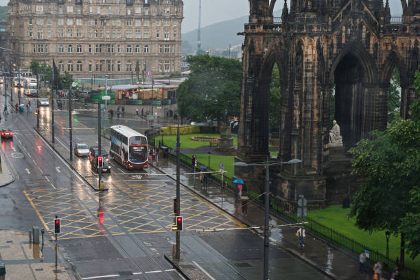 Buses and City Trains in Prices street , Edinburgh, in a rainy afternoon