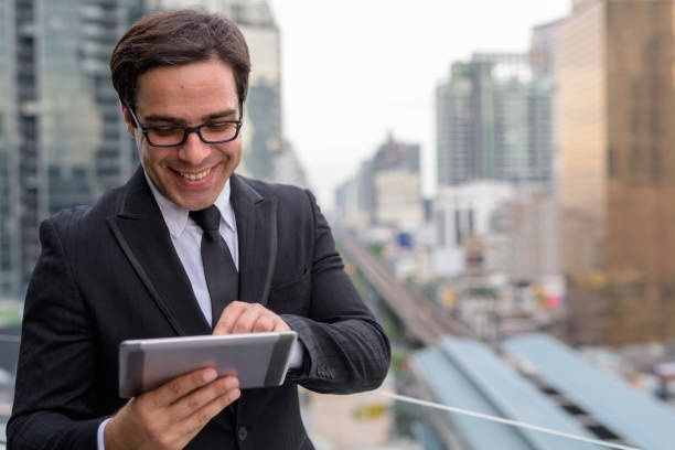 istock Persian businessman using digital tablet at rooftop in Bangkok Thailand 815215442
