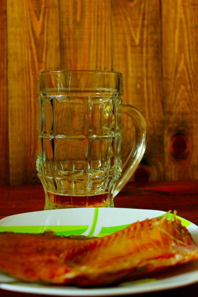 not drunk up glass of beer and sea-roach on the brown background