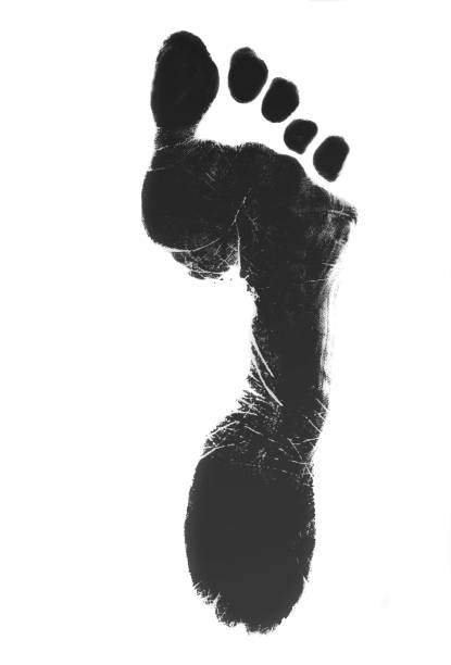a photo of newborn baby footprints made with black ink on white square paper