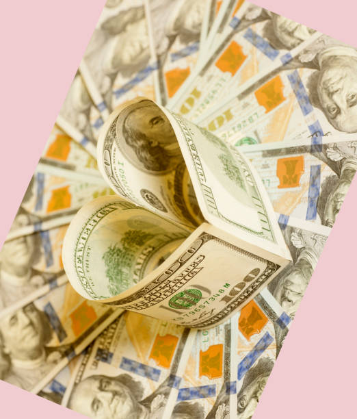 istock Hundred dollar bill in heart shape on dollars background 815235772