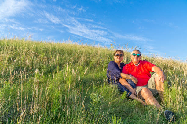 istock Senior couple sitting in grass in countryside 815263740