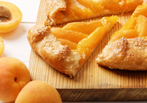 istock Homemade biscuit pie with peaches on white wooden table. 815270748