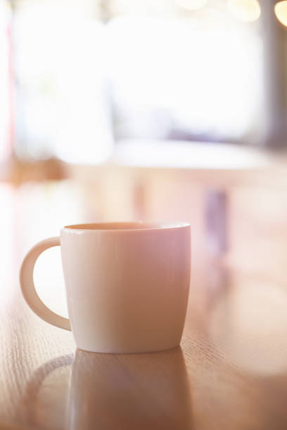 istock Coffee mug on a cozy cafe table with lots of bokeh 815274532
