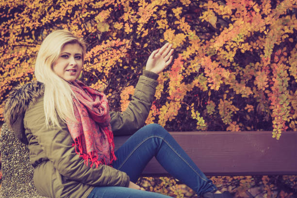 istock Woman relaxing sitting on bench in autumnal park 815285162
