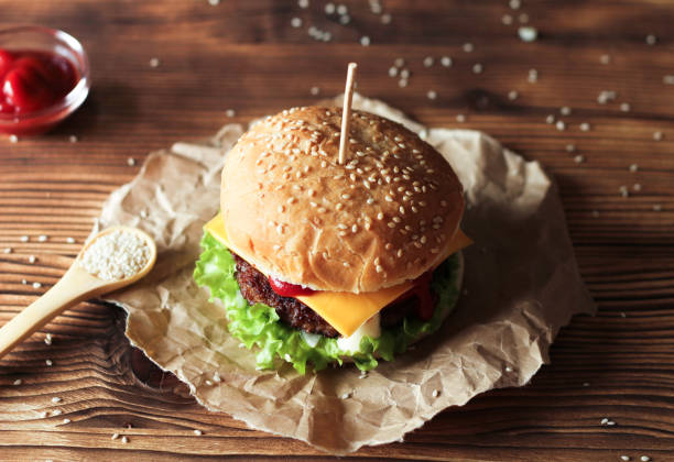 istock Handmade burger with beef, salad and cheese on wooden table. 815334852