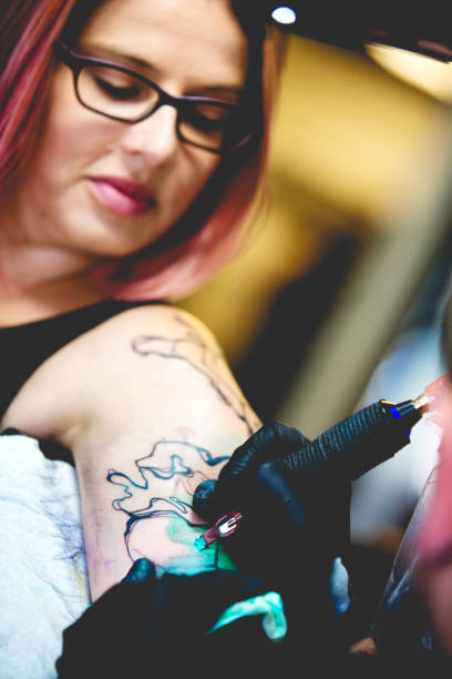 istock 20s Woman Getting a Tattoo 815347168