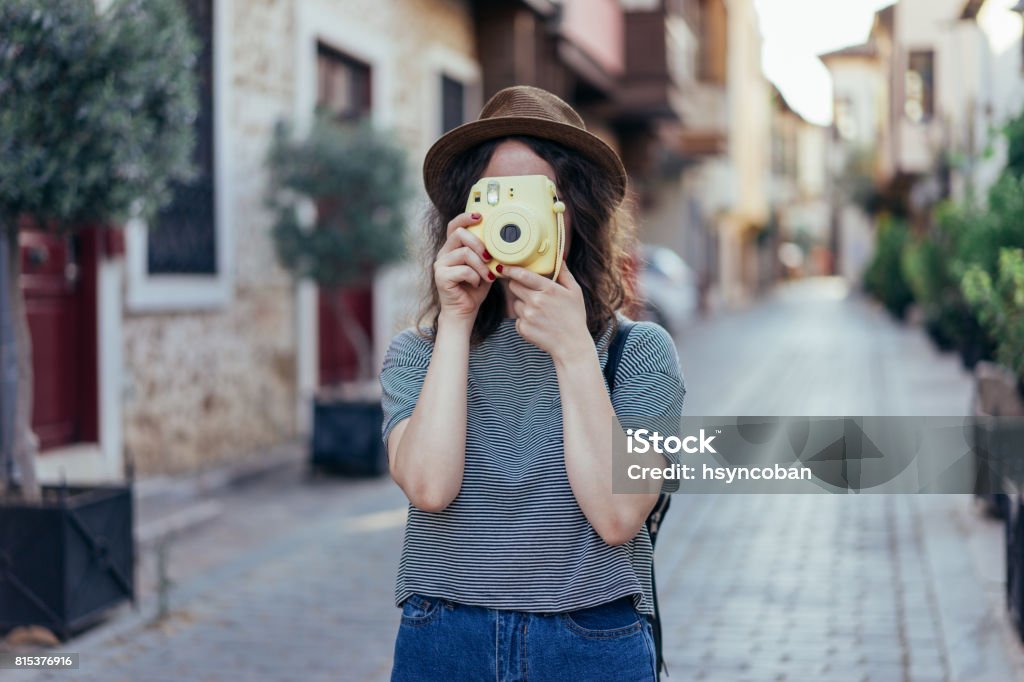 Young girl holding instant camera Young girl holding instant camera in city Instant Camera Stock Photo