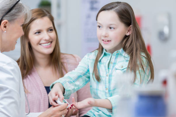 doctor teaches young diabetic patient how to use glaucometer - glaucometer imagens e fotografias de stock