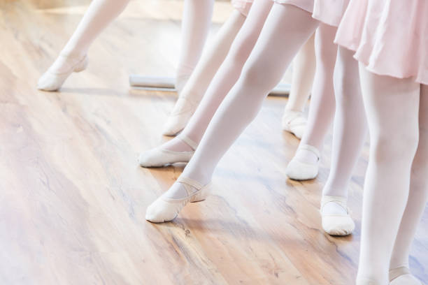 istock Unrecognizable young ballerinas point toes at floor 815403874
