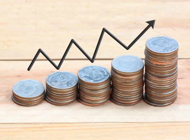 istock Silver coin stack and arrow line in business growth concept on wood floor. 815431030