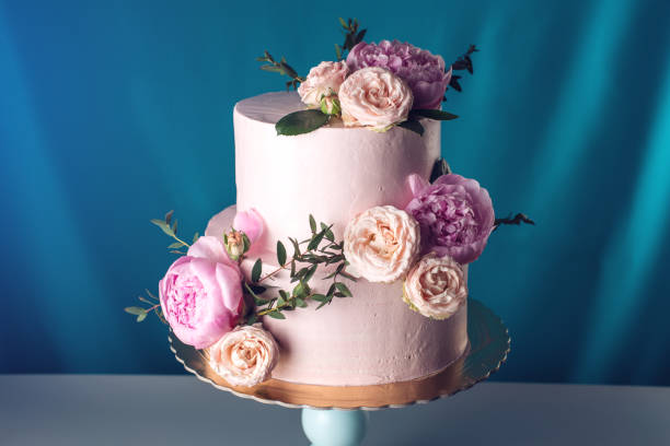 istock Pink cream wedding cake decorated with fresh roses 815440442