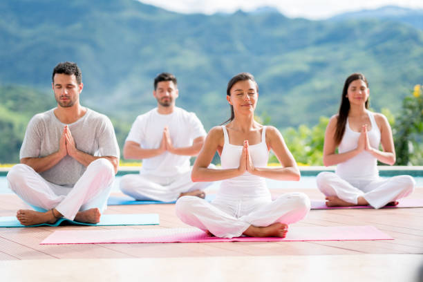 istock Group of people meditating in a yoga class 815458388