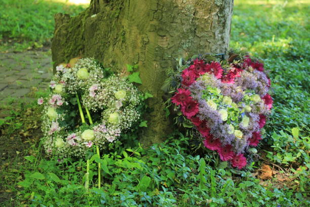 Heart shaped sympathy flowers  or funeral flowers near a tree