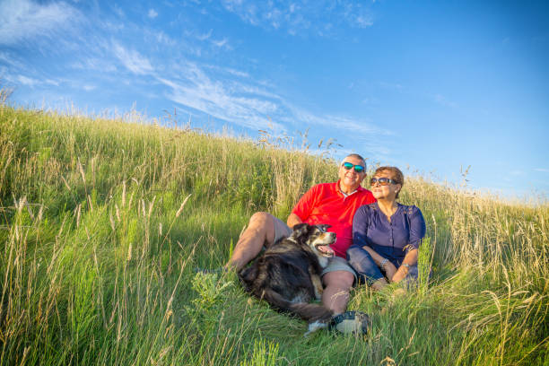 Senior couple sitting in grass in countryside