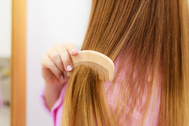 istock Woman combing her long hair closeup 815504082