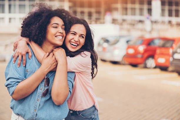 Girlfriends Happy girlfriends holding on the street gay long hair stock pictures, royalty-free photos & images