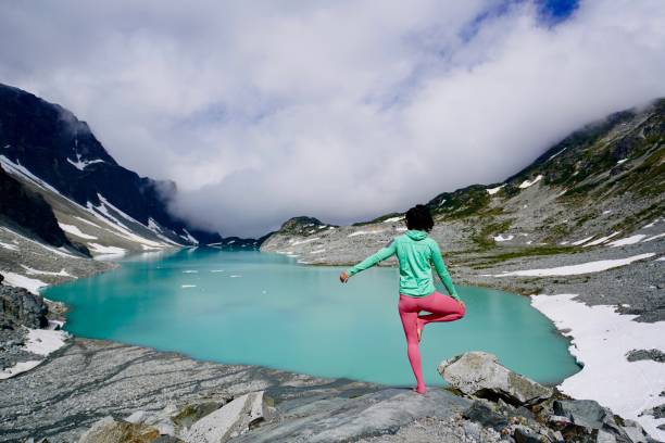 Una chica con vistas a un espectacular lago alpestre en las montañas Rocosas canadienses. - foto de stock