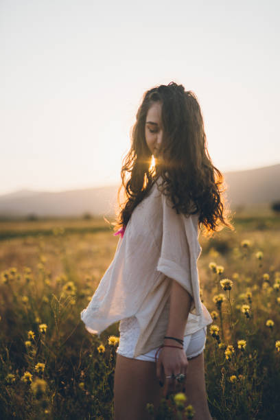 istock Beautiful young woman on a meadow in sunset 815538374