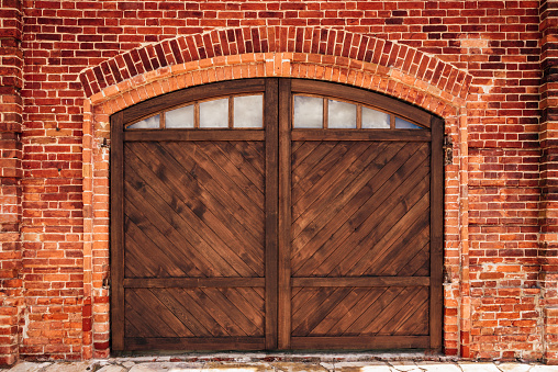 Old Brick Wall with Arch and Wooden Door.