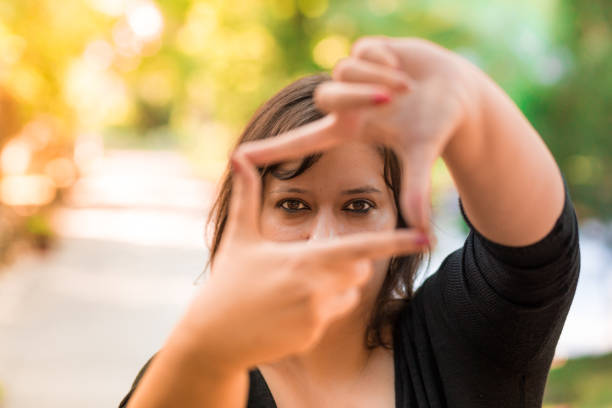 istock Young female photographer framing a shot using her fingers 815570364