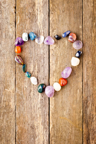 istock Tumbled healing crystals in heart shape on wooden background 815573122
