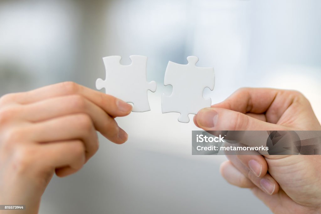 man and woman hand holding jigsaw puzzles, business matching concept Bonding Stock Photo