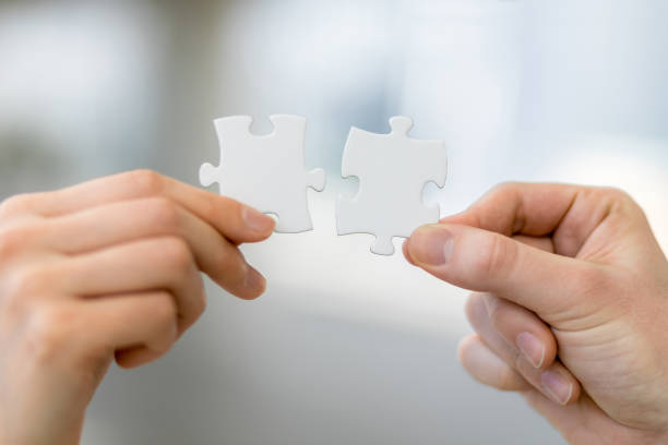 man and woman hand holding jigsaw puzzles, business matching concept - symmetry imagens e fotografias de stock