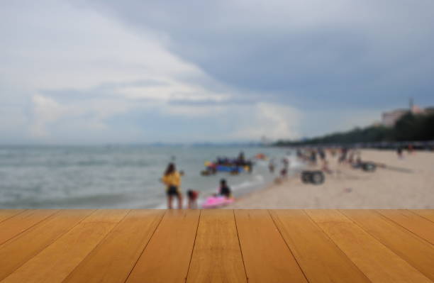 istock Abstract blur image of the beach and wood table use as background 815582098
