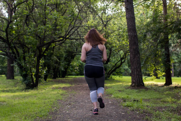 istock Overweight woman back running. Weight loss concept 815591186