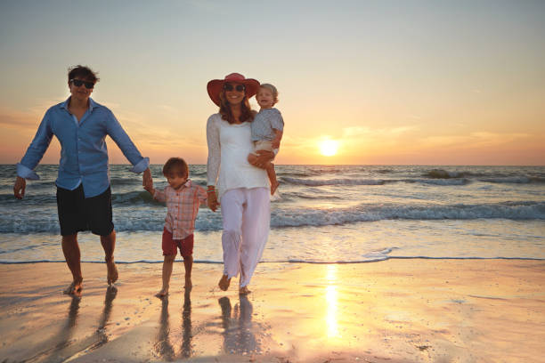 istock Family strolls on the beach at sundown 815601524