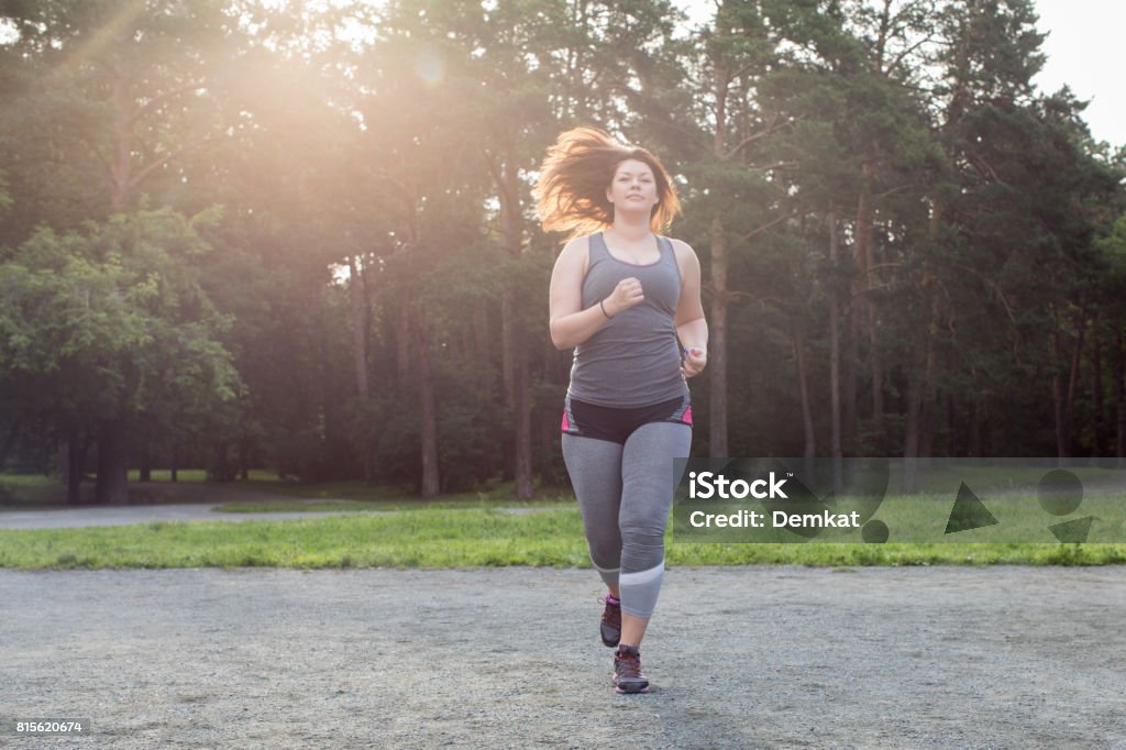 Overweight woman running. Weight loss concept. Overweight woman running in the park . Weight loss concept. Teenager Stock Photo