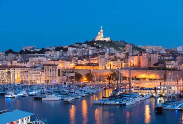 Cathedral illuminated over The Vieux Port (Old Port) in Marseille at Twilight, France