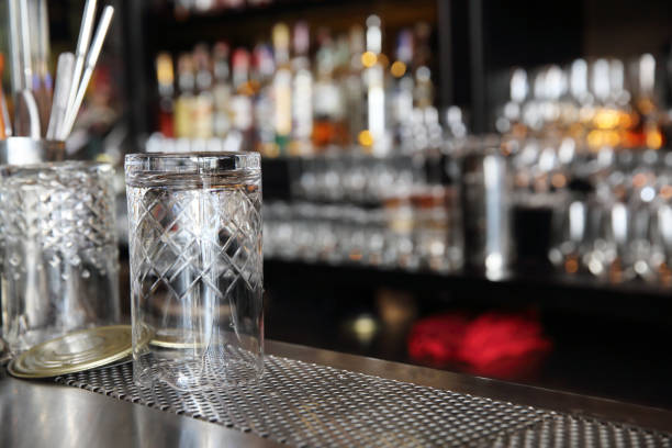 istock Whiskey glasses on bar counter with blur bottles background 815624670