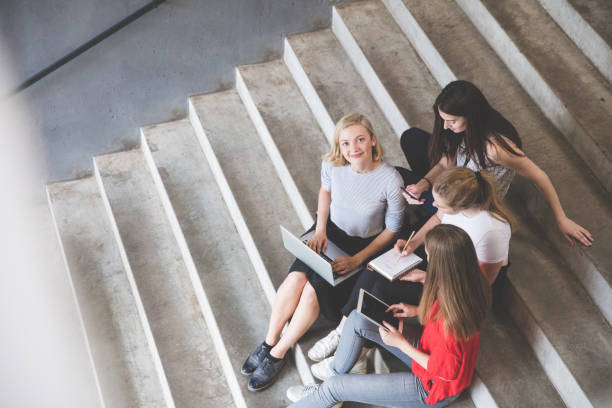 istock Young and happy urban people holding technologies while sitting on steps 815624784