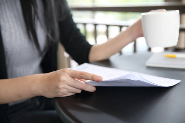 istock woman hand drinking coffee with business paper 815630396