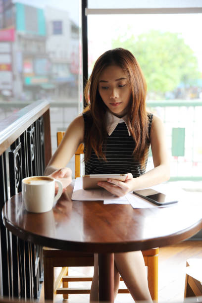 istock Asian woman drinking coffee with tablet 815634990
