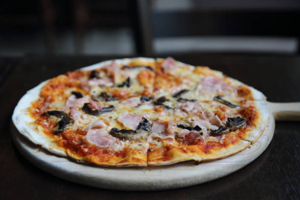 istock pizza ham and mushroom on wood 815635242