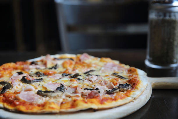 istock pizza ham and mushroom on wood 815635506