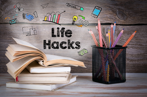 Life Hacks. Stack of books and pencils on the wooden table.