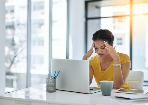 Shot of a young designer looking stressed out while working in an office