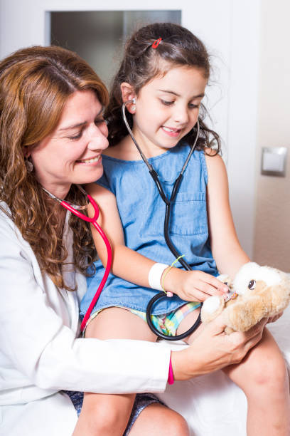 istock Doctor and child paying with a stuffed animal 815642956