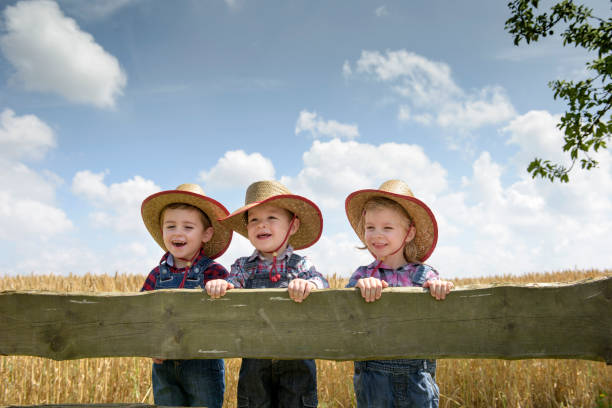 istock three little cowboys outdoors in a field 815658992